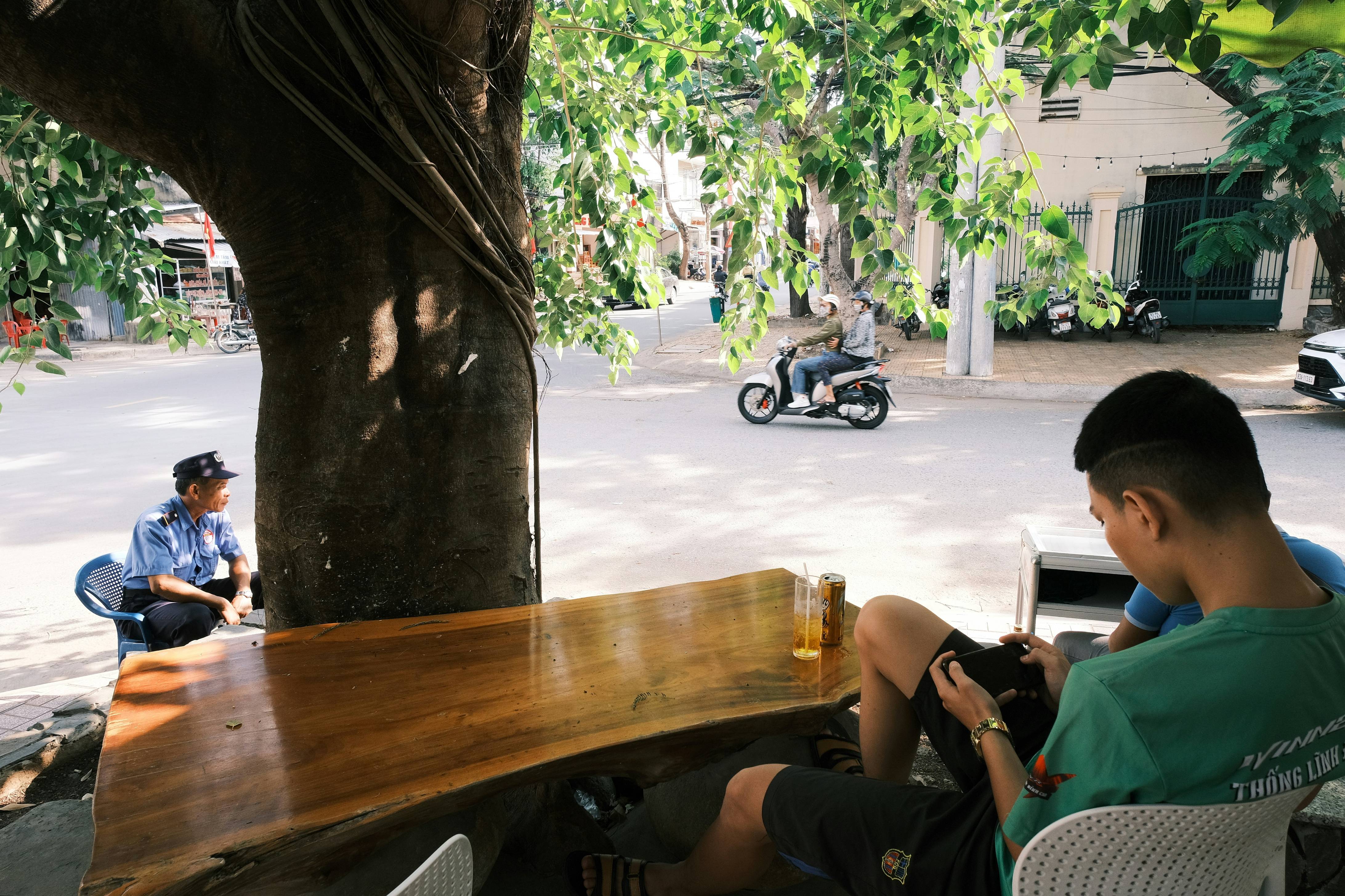 person in black shorts sitting on chair near brown wooden table